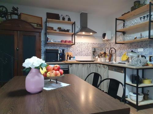 a kitchen with a table with a vase of fruit on it at Apartment with Terrace Nona Pavla in Tolmin