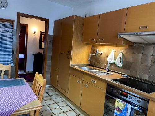 cocina con armarios de madera, mesa, mesa y mesa en Schöne 3-Zimmer-Wohnung nahe Düsseldorf Flughafen und Messe, en Duisburg