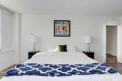 a bedroom with a bed with a blue and white blanket at Urban Charm: 2BR Modern Retreat Close to Downtown in Arlington