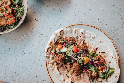 a plate of food with a salad on a table at Malacuna Manchester in Manchester