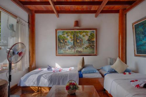 ein Wohnzimmer mit 2 Betten und einem Sofa in der Unterkunft Matahari Tulamben Resort, Dive & SPA in Tulamben