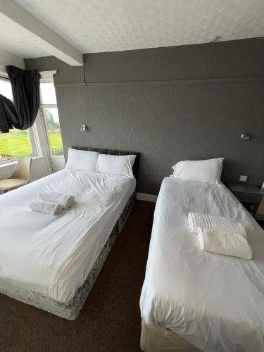 two beds sitting next to each other in a bedroom at Harbour Hotel in Skegness