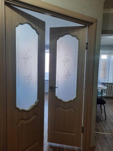 un par de puertas con ventanas en una habitación en Сдам 1-комн квартиру в Центре, en Semey
