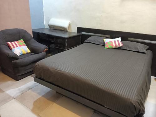 ein Bett und ein Stuhl in einem Schlafzimmer in der Unterkunft Sequence Villa in Mumbai