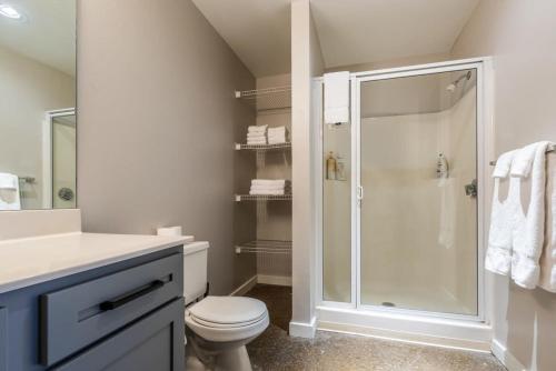 a white bathroom with a shower and a toilet at 3BR Luxury Historic Loft with Gym by ENVITAE in Kansas City