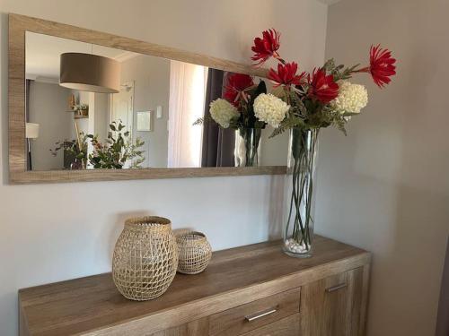 a vase of flowers sitting on a dresser under a mirror at Ruim Penthouse Elviria Marbella met groot terras in Marbella