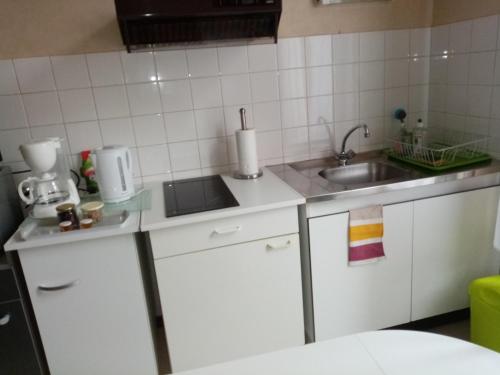 eine kleine Küche mit weißen Schränken und einem Waschbecken in der Unterkunft Studio Danton in Troyes