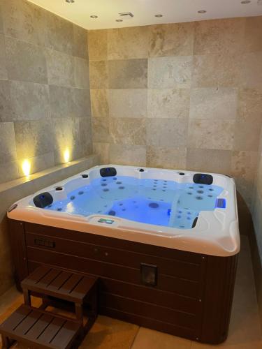 una gran bañera de hidromasaje en una habitación con luces en La nuit de rêve Suite privative Jaccuzi Sauna Suite 2, en Crouy