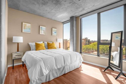 1 dormitorio con 1 cama blanca grande y ventanas grandes en 3BR Elegant Glass Penthouse Pool With Deck & Gym en Chicago
