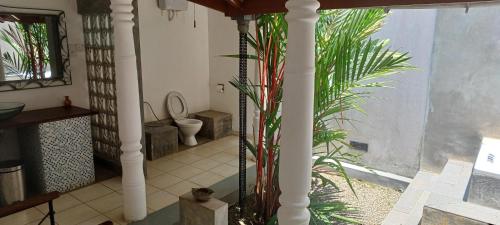 a bathroom with a toilet and some plants at WG - Wathurugama in Gampaha