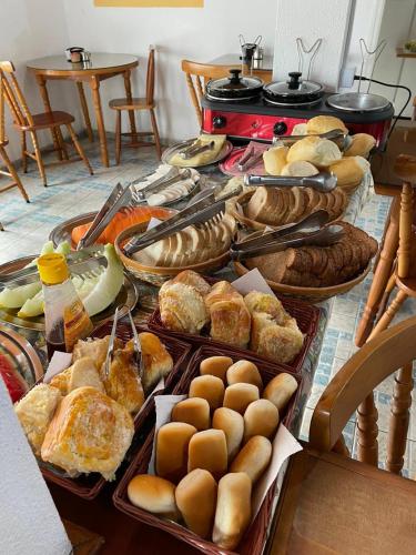 a table full of different types of bread and pastries at Pousada Vila Tio Lé in Campos do Jordão