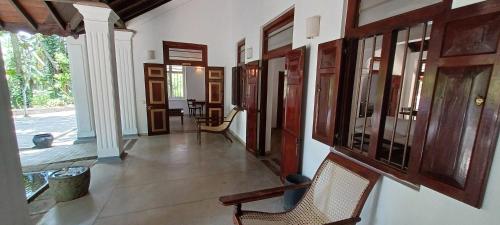 a hallway with wooden doors and chairs in a house at WG - Wathurugama in Gampaha