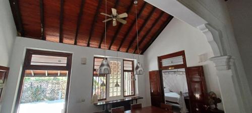 a living room with a ceiling fan and windows at WG - Wathurugama in Gampaha
