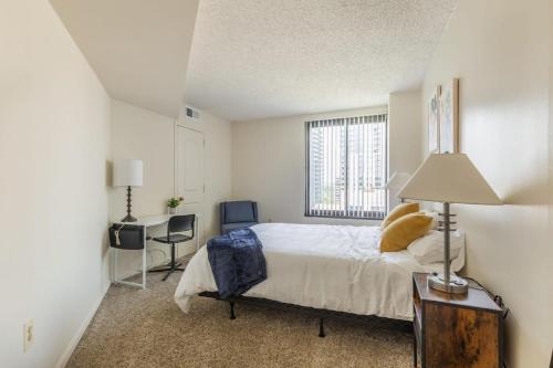 Schlafzimmer mit einem Bett, einem Schreibtisch und einem Fenster in der Unterkunft 2BR Executive Apartment with Balcony in Arlington