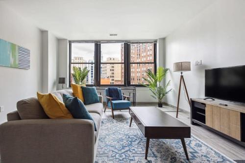 a living room with a couch and a flat screen tv at 2BR Premium Downtown Suite in Detroit