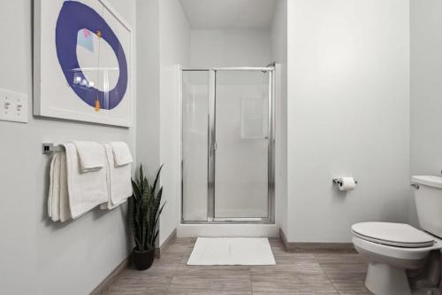 een badkamer met een douche, een toilet en een tapijt bij 2BR Premium Downtown Suite in Detroit