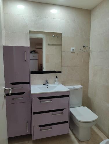 ein Badezimmer mit Waschbecken, Toilette und Spiegel in der Unterkunft LaMiranda Benidorm in Benidorm