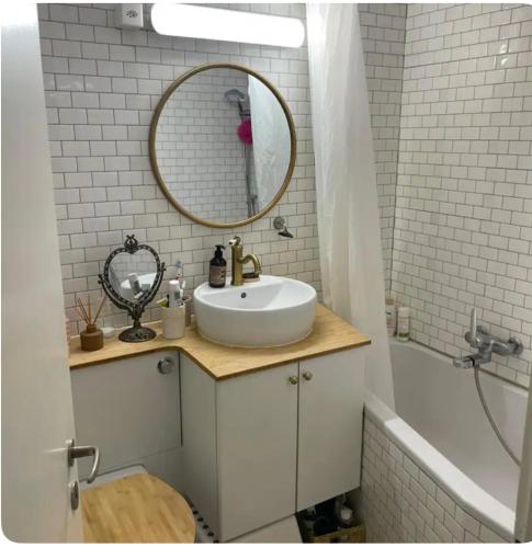 ein Badezimmer mit einem Waschbecken, einem Spiegel und einer Badewanne in der Unterkunft Appartment 15min from Zürich by train at the Lake in Oberrieden
