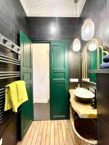La salle de bains est pourvue d'une porte verte et d'un lavabo. dans l'établissement Superbe T2 cocon en hyper centre-ville d'Ajaccio, à Ajaccio