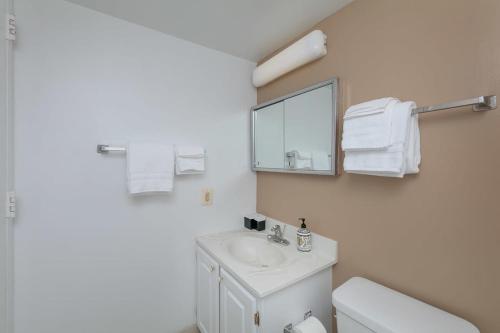 a white bathroom with a sink and a mirror at 2BR Central Apartment Spacious Layout & Balcony in Arlington