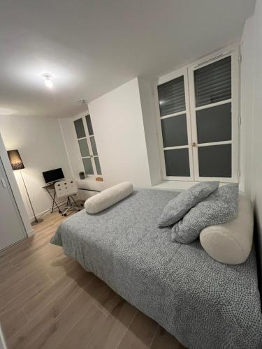 a white bedroom with a bed and a desk at Chambre Douche WC privés - calme - terrasse in Saint-Germain-en-Laye