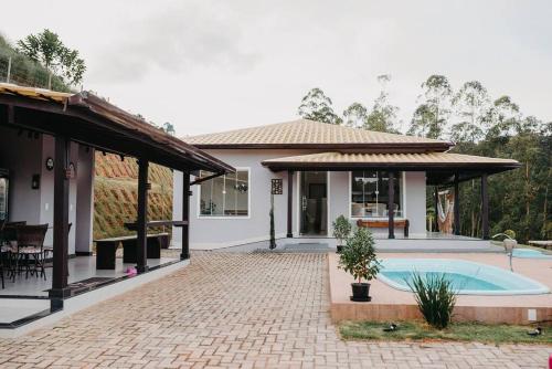 una casa con piscina en el patio trasero en Casa de Campo completa nas montanhas capixabas, en Marechal Floriano
