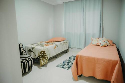 1 dormitorio con 2 camas y 1 silla en Casa de Campo completa nas montanhas capixabas en Marechal Floriano