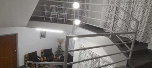 a room with a staircase with chairs and a table at Medajied Guest House in Shillong