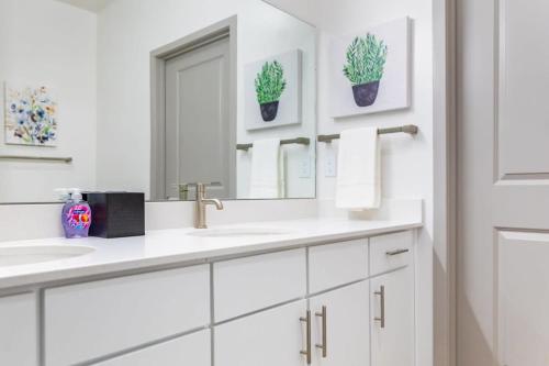 a white bathroom with two sinks and a mirror at 2BR Luxury New Apartment with Outdoor Pool in Kansas City