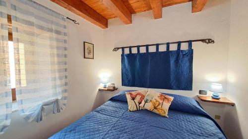 - une chambre avec un lit bleu et un rideau bleu dans l'établissement A Nicaredda, à Cefalù
