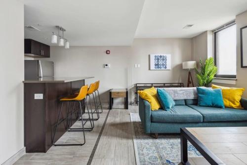 a living room with a couch and a kitchen at 2BR Executive Downtown Apartment by ENVITAE in Detroit