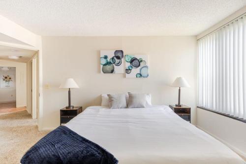- une chambre avec un grand lit blanc et deux lampes dans l'établissement 2BR Serene Executive Retreat with Balcony, à Arlington