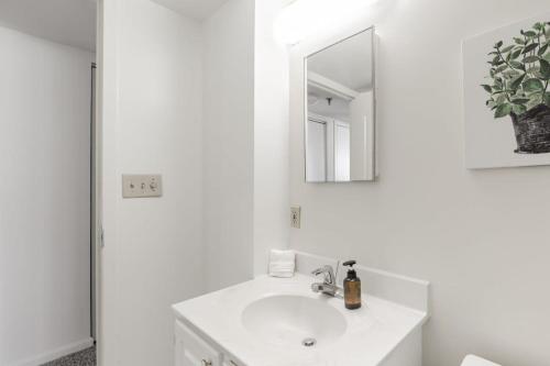 a white bathroom with a sink and a mirror at 2BR Serene Executive Retreat with Balcony in Arlington