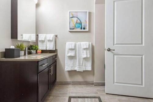 Łazienka z umywalką i białymi drzwiami w obiekcie 2BR Executive Downtown Apartment by ENVITAE w mieście Detroit