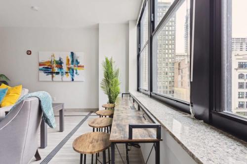 a living room with a table and chairs and windows at 2BR Executive Downtown Apartment in Detroit