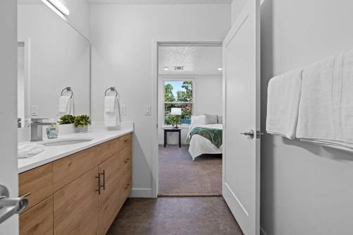 1 dormitorio y baño con lavabo y espejo. en 2BR Escape Balcony Gym and Premier Comfort en Salt Lake City