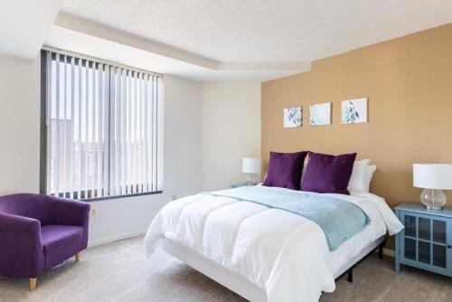 um quarto com uma cama grande e uma cadeira roxa em 2BR Serene Executive Retreat with Balcony em Arlington