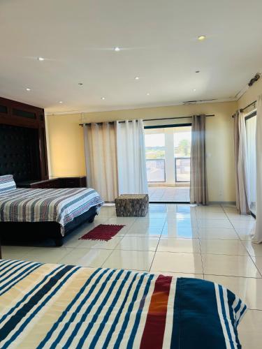 1 dormitorio con 2 camas y ventana grande en Kholofelo house, en Saldanha