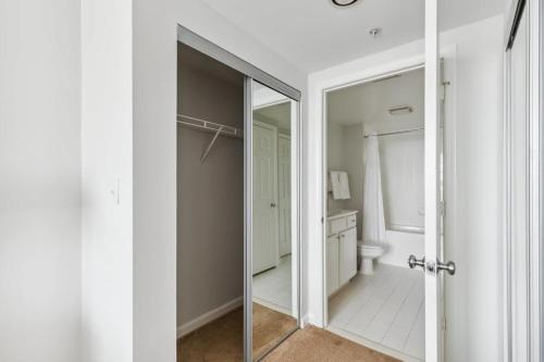 a bathroom with a mirror and a toilet at 2BR Luxury City Suite With Gym & Pool in Arlington