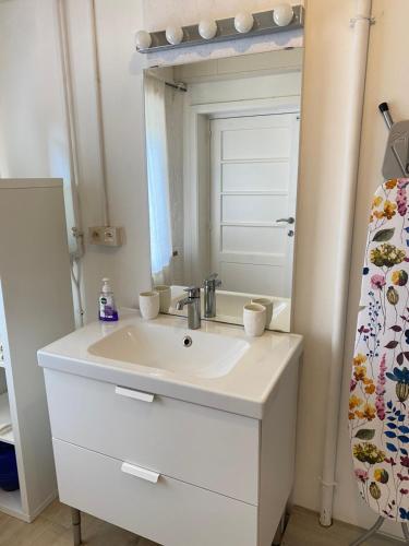 uma casa de banho com um lavatório branco e um espelho. em Chambre Chants d'oiseaux em Bruxelas