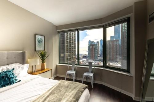 een slaapkamer met een bed en uitzicht op de stad bij 2B 2BA Exquisite Apartment With Views, Indoor Pool & Gym by ENVITAE in Chicago