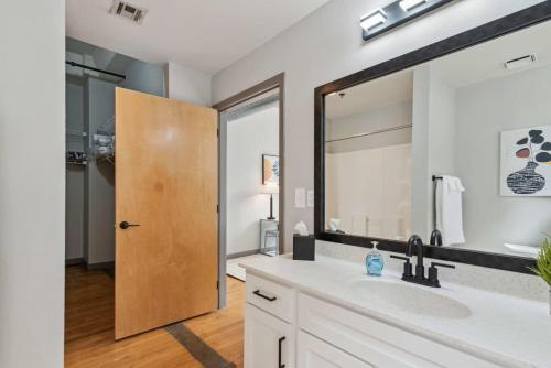 a bathroom with a sink and a large mirror at Spacious & Elegant 2BR Downtown Retreat in Kansas City