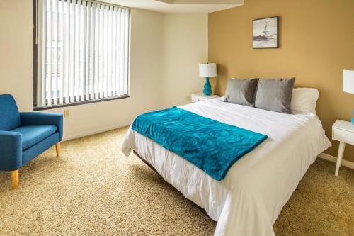 - une chambre avec un grand lit et une chaise bleue dans l'établissement 2BR Premium A-Location Apartment, à Arlington