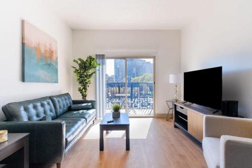 a living room with a couch and a flat screen tv at 3BR Modern Downtown Apartment with Gym & Office in Charlotte