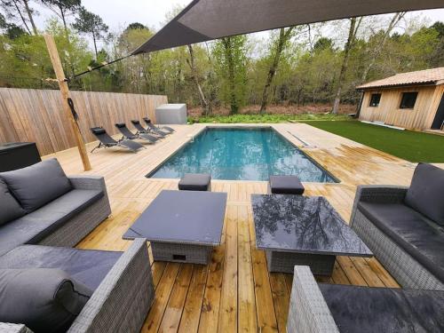 une cour arrière avec une piscine et une terrasse en bois dans l'établissement Villa idéalement située sur Arès, à Arès