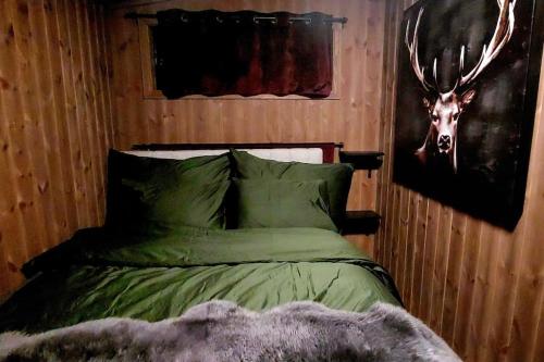 um quarto com uma cama com uma cabeça de veado na parede em Cabin Aurora Borealis em Sommarøy