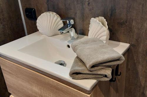 a bathroom sink with a towel and a faucet at Cabin Aurora Borealis in Sommarøy