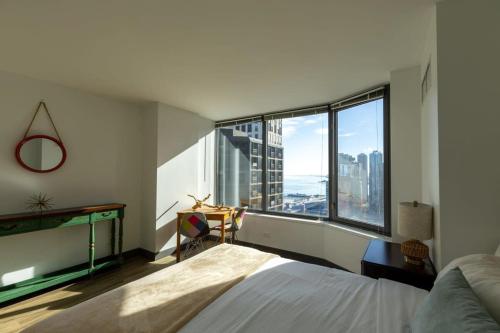 ein Schlafzimmer mit einem Bett und einem großen Fenster in der Unterkunft Ultimate 3BR Luxury Suite near Navy Pier with Gym & Pool by ENVITAE in Chicago