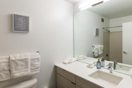 uma casa de banho branca com um lavatório e um espelho em Ultimate 3BR Luxury Suite near Navy Pier with Gym & Pool by ENVITAE em Chicago