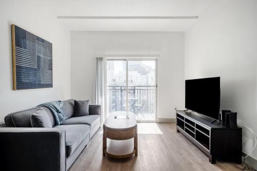 a living room with a couch and a flat screen tv at 4BD Premium Family Apartment with Gym in Charlotte